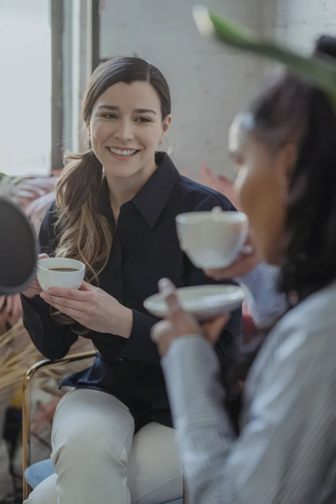 Dos amigas conversando con una taza de café