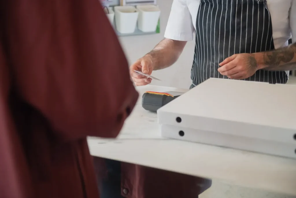 Cliente pagando con tarjeta en la caja de un restaurante