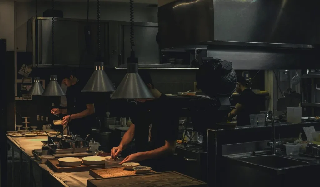 Equipo de cocina preparando platos durante el servicio